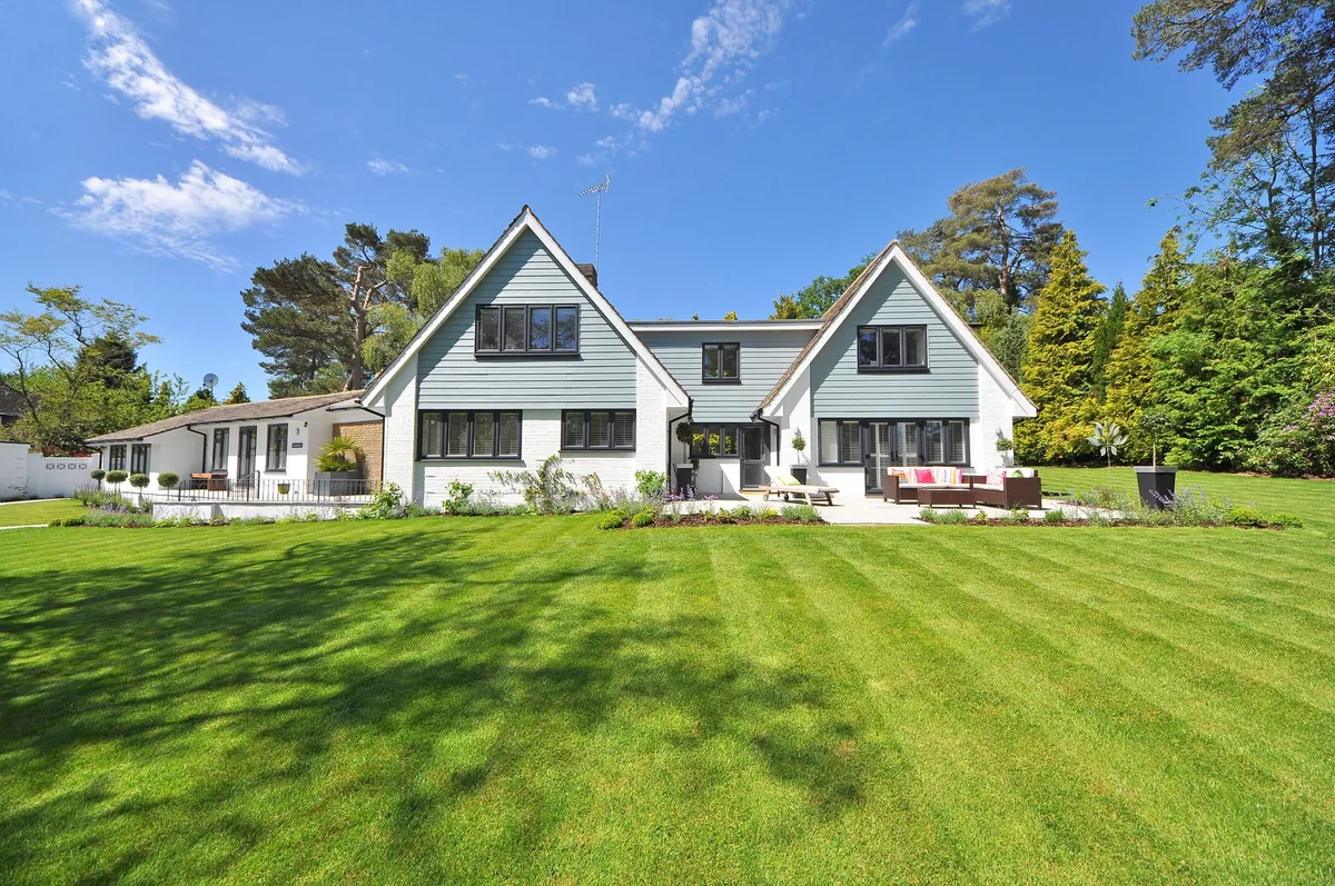 Modern home behind a wide, freshly mowed lawn showing clean mowing stripes